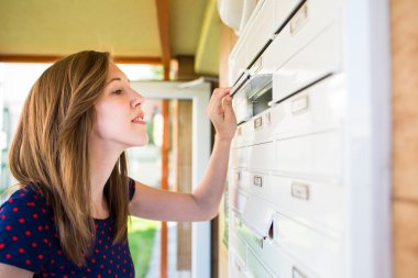 Woman checking her mailbox for new letters clipart