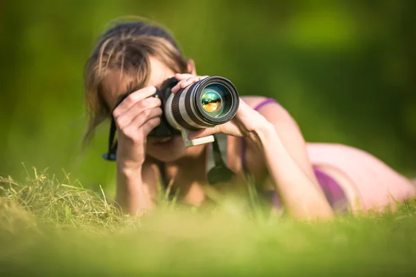 Bonita fotógrafa acostada en hierba —  Fotos de Stock