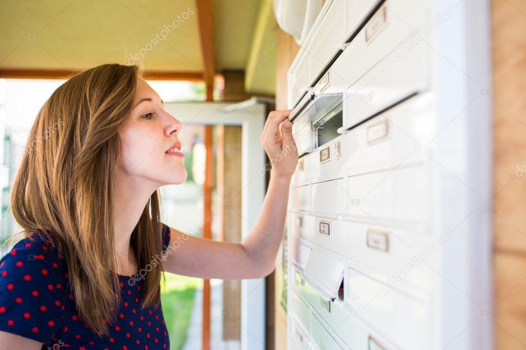 Woman checking her mailbox for new letters