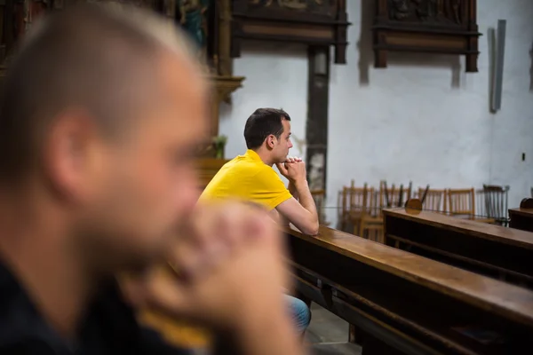 En man som ber i en kyrka — Stockfoto