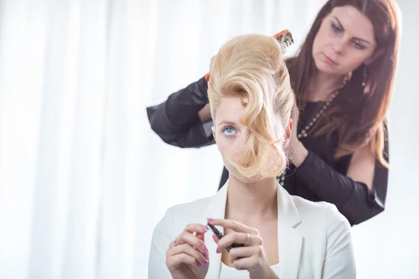 Arbetar på en ung kvinnas hår frisyr-konstnär — Stockfoto