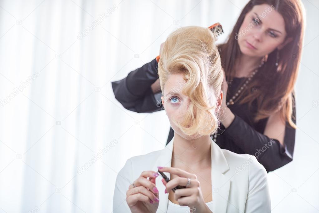 Hairstyle artist working on a young woman's hair