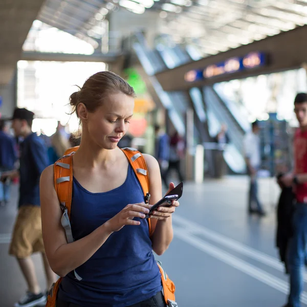 Mujer en una estación de tren, enviando un mensaje —  Fotos de Stock