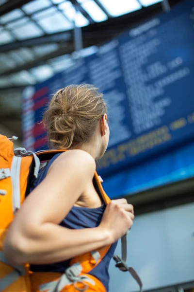 Mujer en una estación de tren, abordando un tren — Foto de Stock