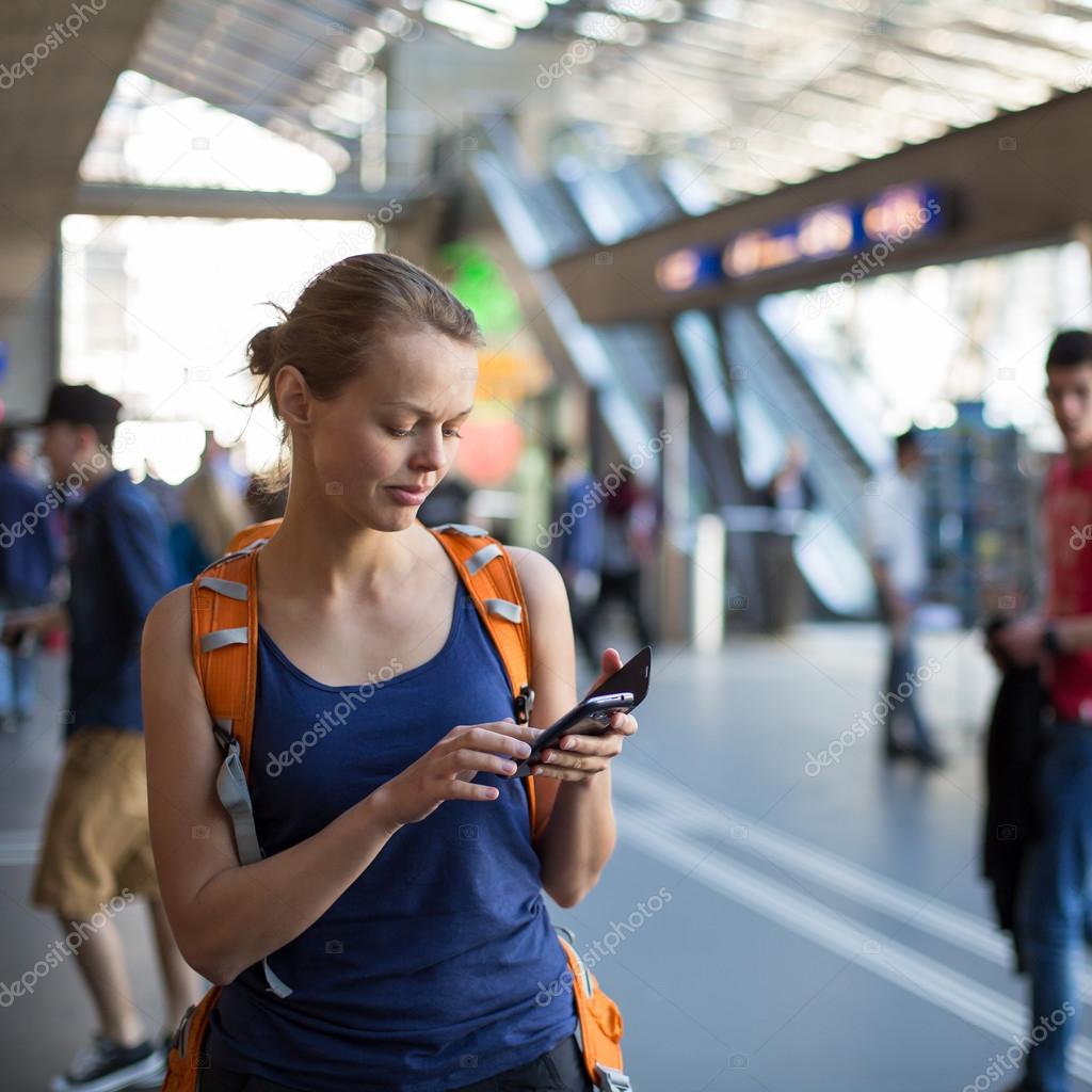 Woman in a train station, sending message