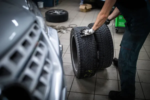 Automechanik Měnící Pneumatiky Automobilu Opravně Garáži Mělký Dof Barevný Tónovaný — Stock fotografie