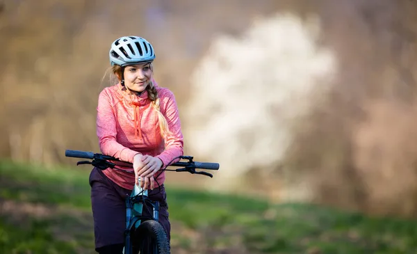 年轻的女人骑着她的山地自行车去兜风 穿过城市的界限 每天都要做一些有氧运动 — 图库照片