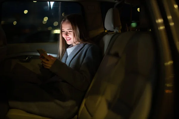 Młoda Kobieta Komórką Siedząca Tylnym Siedzeniu Samochodu Szykująca Się Podróży — Zdjęcie stockowe