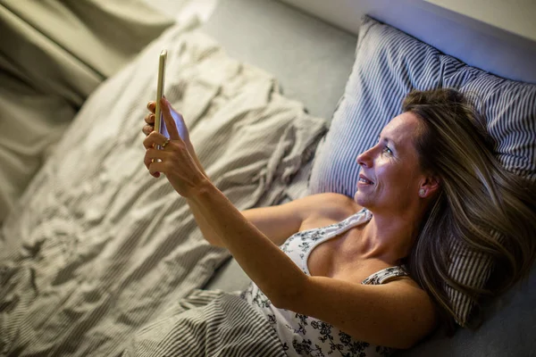 Csinos Középkorú Használja Táblagépét Mielőtt Lefekszik Aludni Este — Stock Fotó