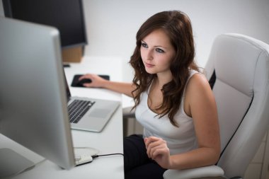 Evdeki bilgisayarda çalışan genç bir kadın.