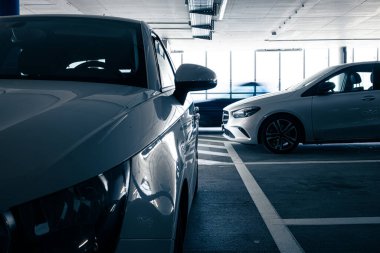 Yeraltı otoparkı. Garajda hiç insan olmayan arabalar. Otoparkın içinde bir sürü araba var. Otomobilli yeraltı otoparkı (renk tonlu resim)