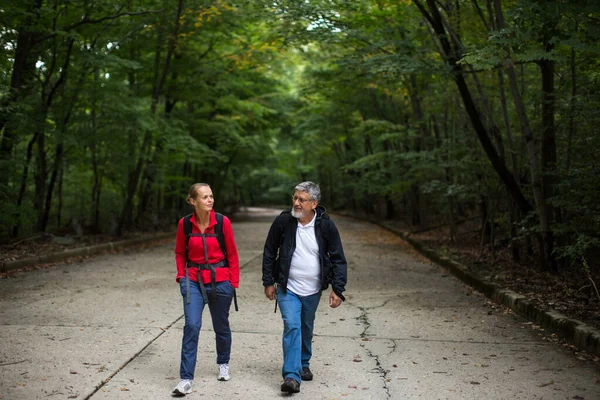 积极英俊的老年人散步 在森林小径上徒步旅行 和女儿一起享受退休生活 — 图库照片
