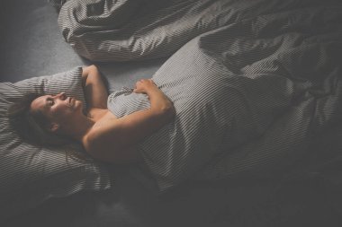 Güzel, orta yaşlı bir kadın akşamları yatmadan önce tabletini kullanıyor.