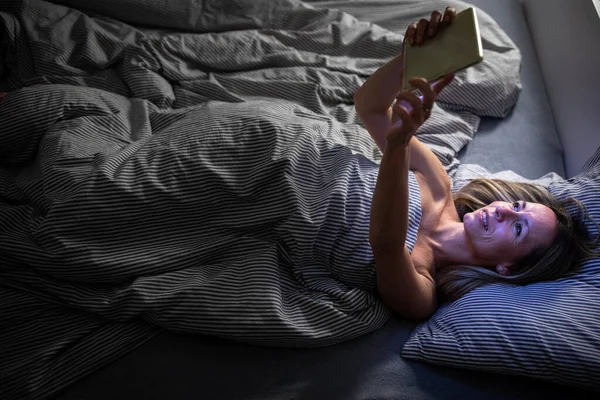 Mulher Meia Idade Usando Seu Computador Tablet Antes Dormir Cama — Fotografia de Stock