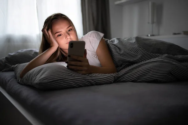 Söt Ung Kvinna Sover Sin Säng Med Sin Mobiltelefon Nära — Stockfoto