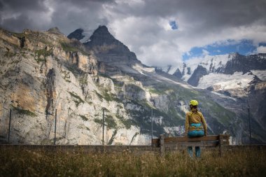 Ferrata üzerinden İsviçre Alplerinde kayaya tırmanan güzel bir bayan tırmanıcı.