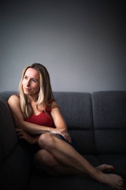 Depresyondaki orta yaşlı kadın evde üzgün, yalnız, endişeli (renkli tonlu görüntü))