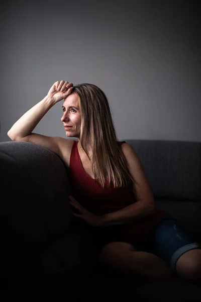 ソファでリラックスした家の中年女性 カラートーンのイメージ — ストック写真