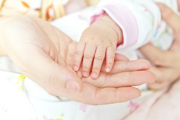 Close-up van baby's hand hebt moeder's hand — Stockfoto