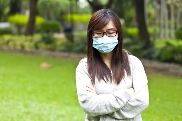 Žena nosit ochrannou masku v parku — Stock fotografie