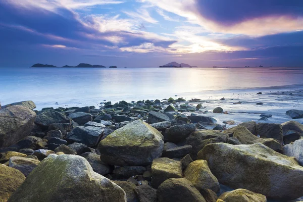 Pedras marinhas ao longo da costa ao pôr do sol — Fotografia de Stock
