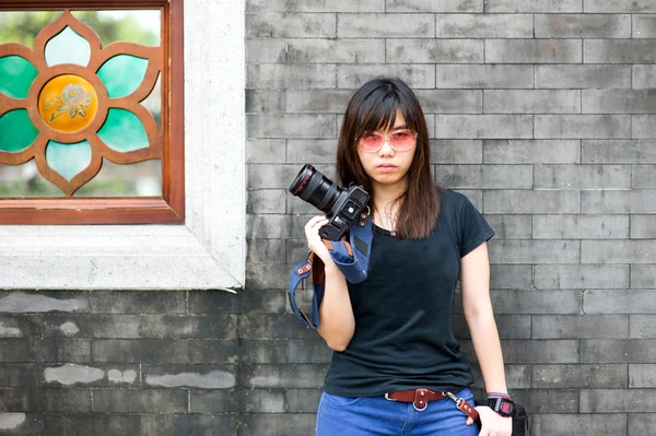 Moda de uma menina usando uma listrada segurando a câmera — Fotografia de Stock