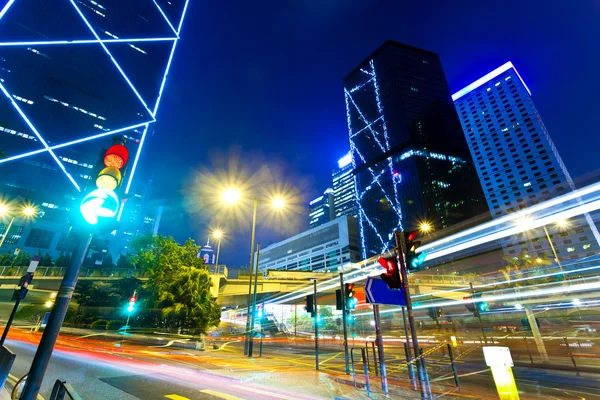 Light trails with modern buildings background — Stock Photo, Image