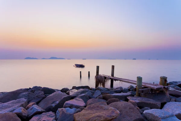 Holzbrücke bei Sonnenuntergang entlang der Küste — Stockfoto