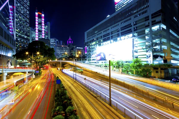 Tráfico en el centro por la noche en la ciudad moderna — Foto de Stock