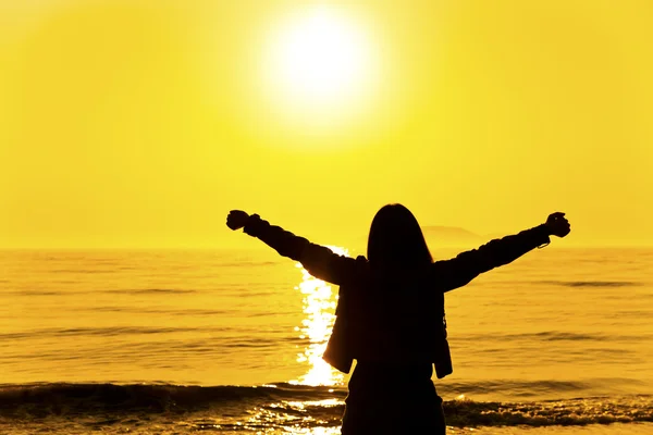 Silhouette of a woman relaxing at sunset — Stock Photo, Image