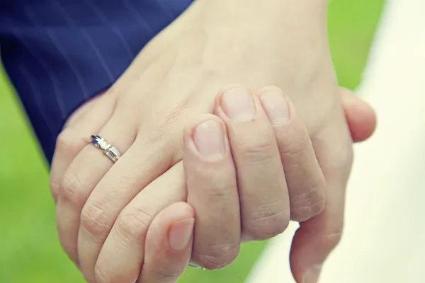 Pareja cogida de la mano con anillo de boda — Foto de Stock