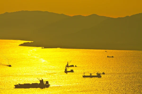 Masowiec statek w zachód słońca w morzu — Zdjęcie stockowe