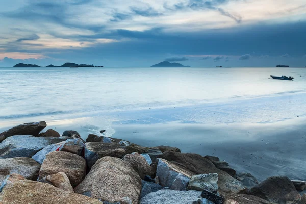 Puesta de sol en la costa con fondo de piedras marinas —  Fotos de Stock