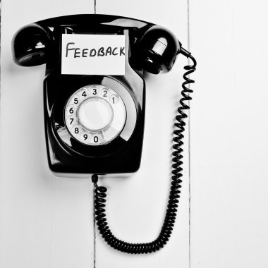 Retro phone with a note to give feedback clipart
