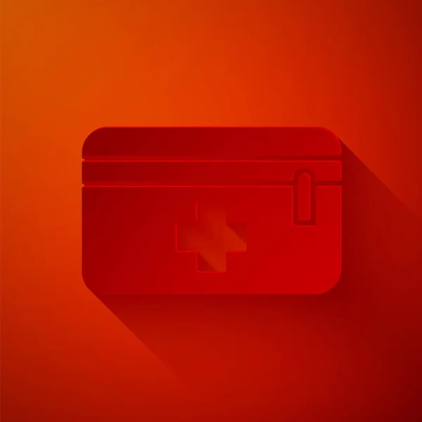 Papírvágás Elsősegély készlet ikon elszigetelt piros háttérrel. Orvosi doboz kereszttel. Orvosi felszerelés vészhelyzet esetére. Egészségügyi koncepció. Papírművészeti stílus. Vektorillusztráció — Stock Vector