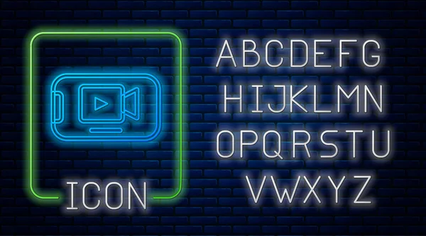 Gloeiende neon Online play video icoon geïsoleerd op bakstenen muur achtergrond. Smartphone en filmstrip met speelbord. Neon licht alfabet. Vector — Stockvector