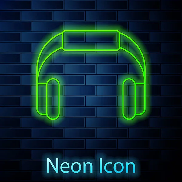 Glowing neon line Headphones icon isolated on brick wall background. Earphones. Concept for listening to music, service, communication and operator. Vector — Stock Vector