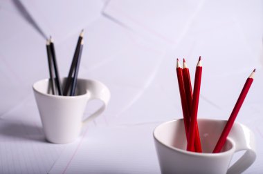siyah ve kırmızı kalem iki beyaz fincan'dur