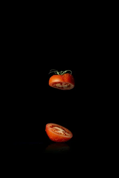 Czerwony pomidor pokroić w pół na czarnym tle — Zdjęcie stockowe