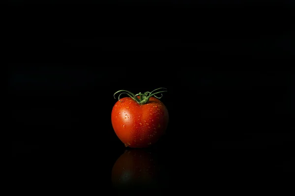 Ganze rote Tomate auf schwarzem Hintergrund — Stockfoto