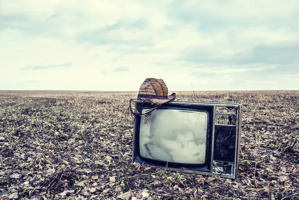 Old TV with hat is an autumn field — Stock Photo, Image