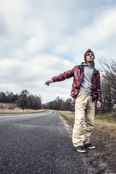 Homem Hailing em uma beira da estrada da estrada — Fotografia de Stock