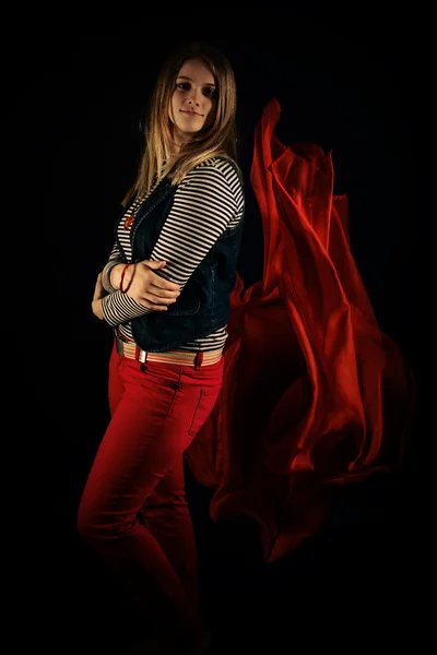 Beautiful girl against red fabric in the dark — Stock Photo, Image