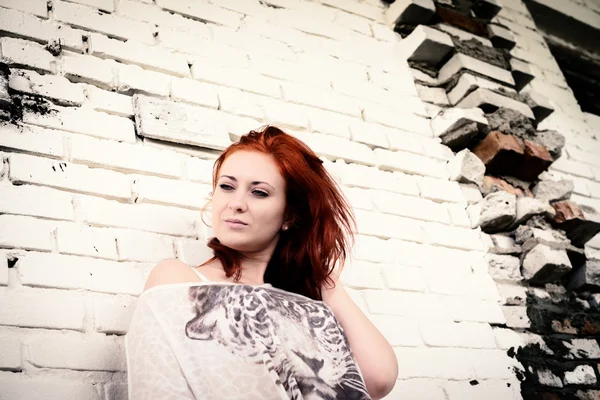 Belle fille avec les cheveux rouges en plein air contre le mur de briques — Photo