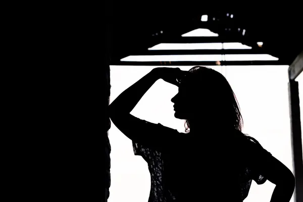 Silhouet van mooi meisje buiten in oud pakhuis — Stockfoto