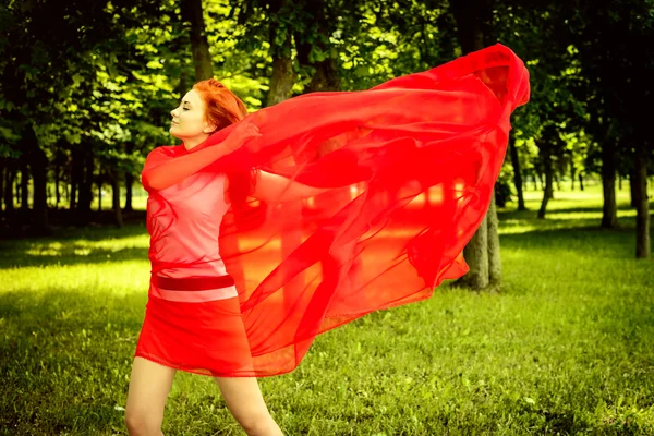 Glad kvinna i röd jublar vind — Stockfoto