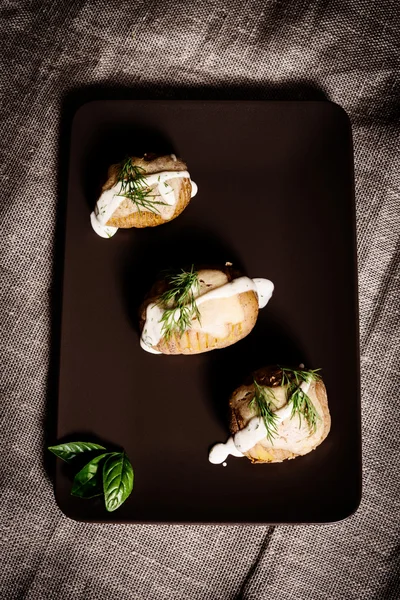 Potatoes are served on dish with basil sauce and fennel — Stock Photo, Image