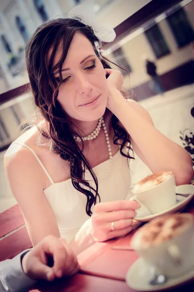 Unusual loving wedding couple in cafe drinks cappuccino — Stock Photo, Image