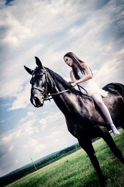 Ongebruikelijk bruid op bruiloft op zwarte paard buitenshuis — Stockfoto