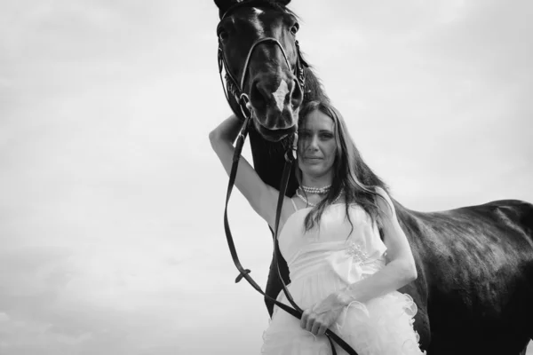 Unusual bride at wedding on black horse outdoors — Stock Photo, Image